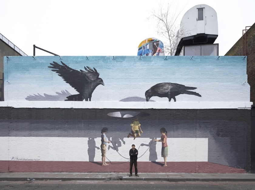 The artist in front of his Shoreditch mural.