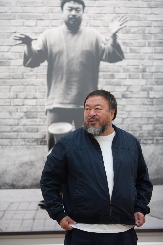 Ai Weiwei with one of his photographs from Dropping a Han Dynasty Urn, Royal Academy of Arts, 2015. Ph. Dave Parry, Courtesy of Royal Academy of Arts, London. 